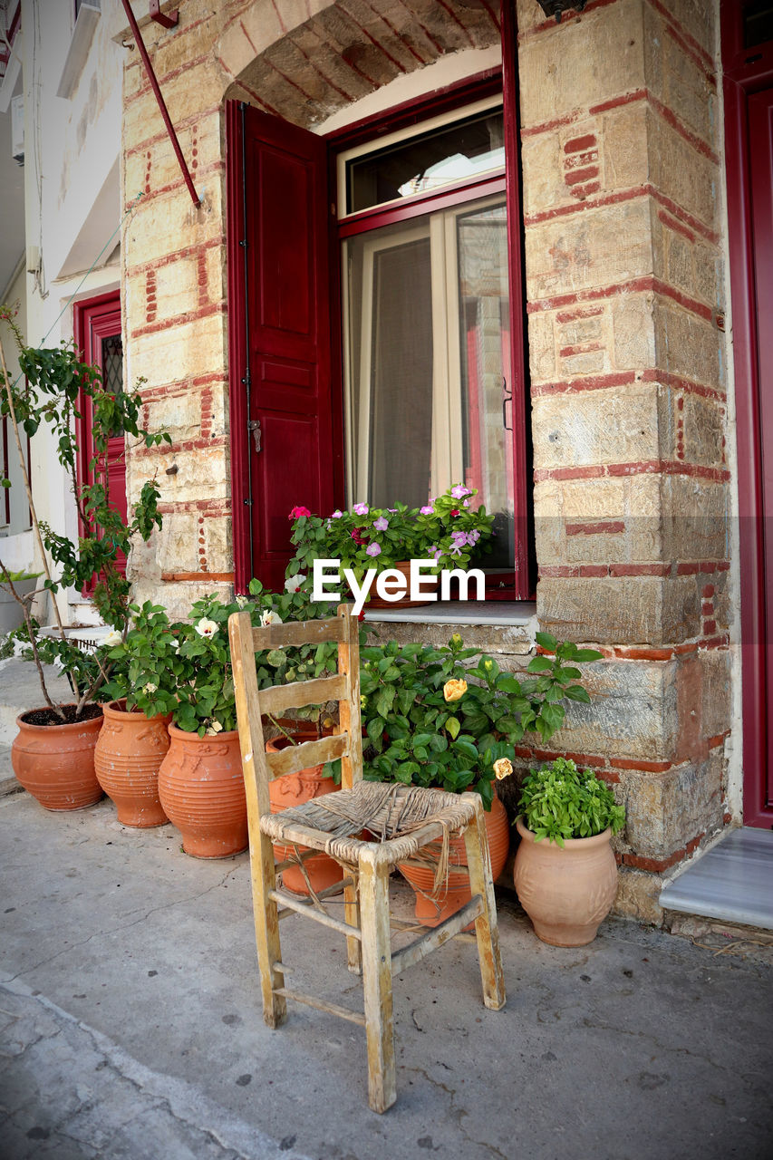 architecture, red, building exterior, built structure, window, plant, home, potted plant, building, door, no people, seat, house, entrance, courtyard, wood, chair, nature, day, flowerpot, residential district, porch, growth, cottage, flower, outdoors, wall, backyard, interior design, front stoop, houseplant, table, wall - building feature, flowering plant, absence, front or back yard, old, food and drink