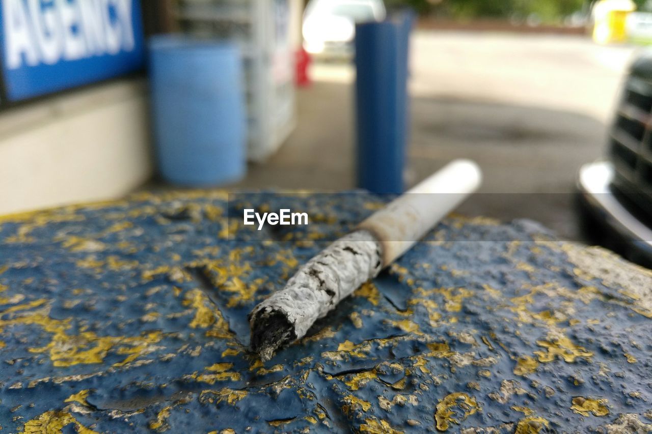 Close-up of cigarette butt on rock