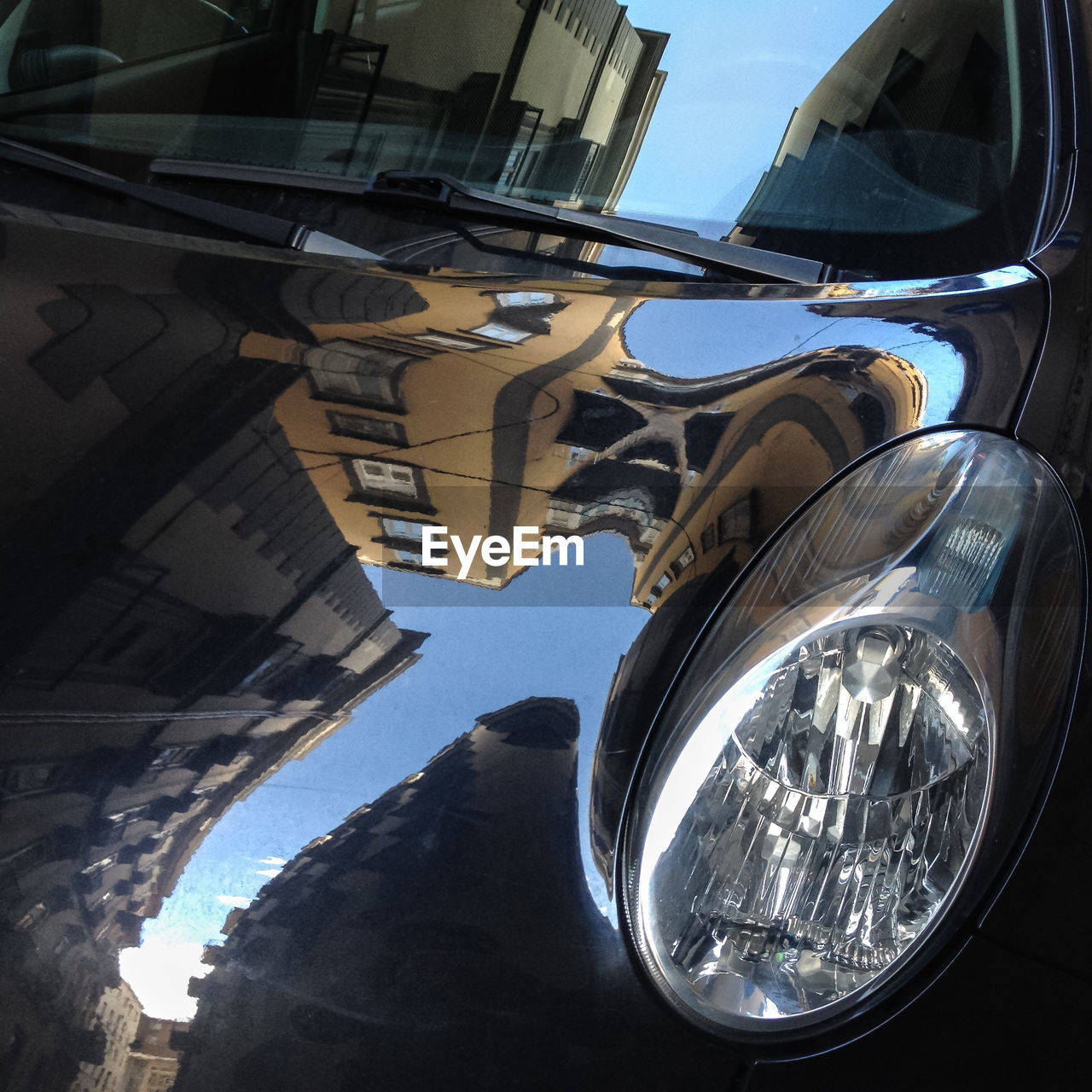 View of city reflection in car bonnet