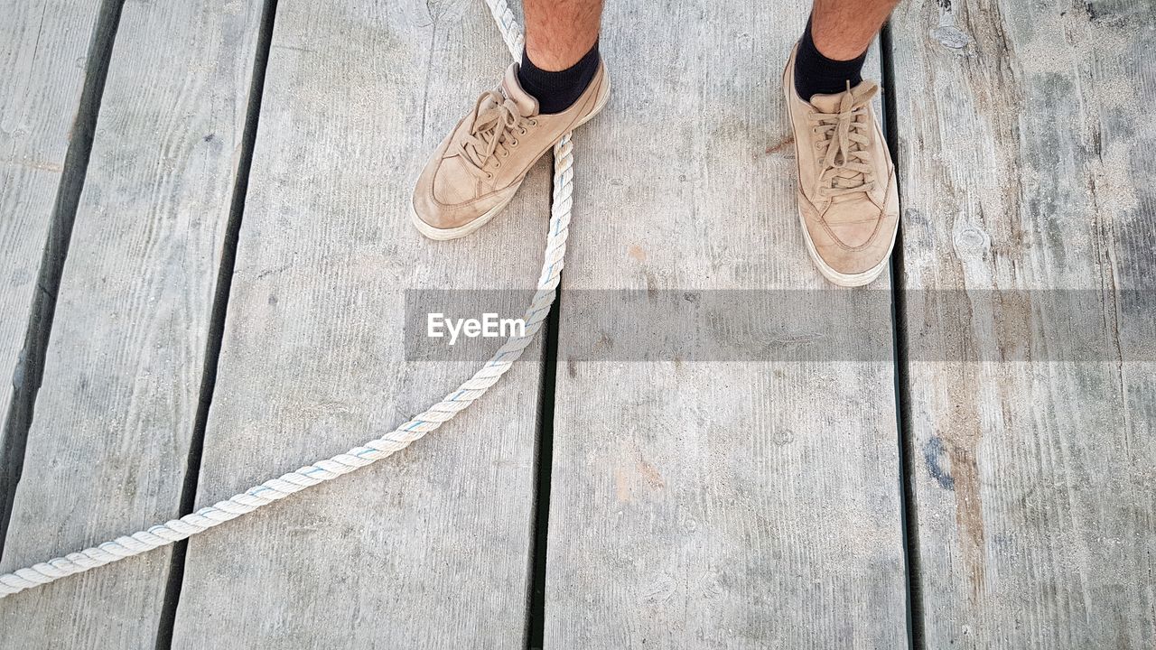 Low section of man standing on pier