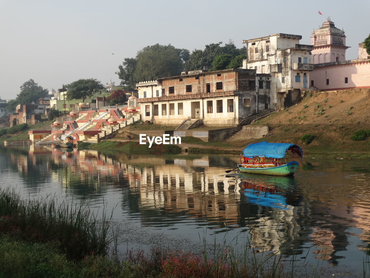 Buildings by lake against sky