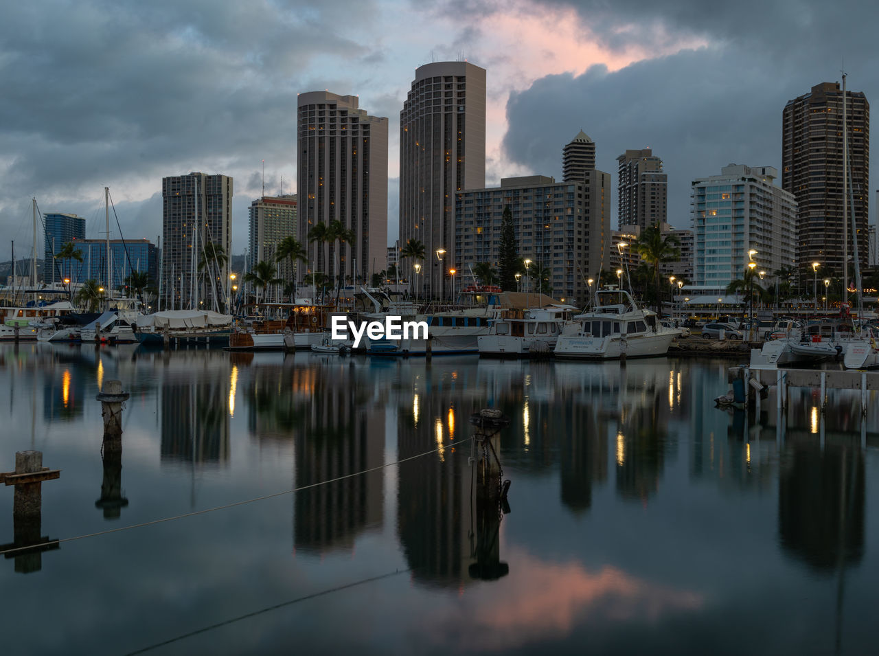 Honolulu skyline reflected in the marina harbor at sunrise