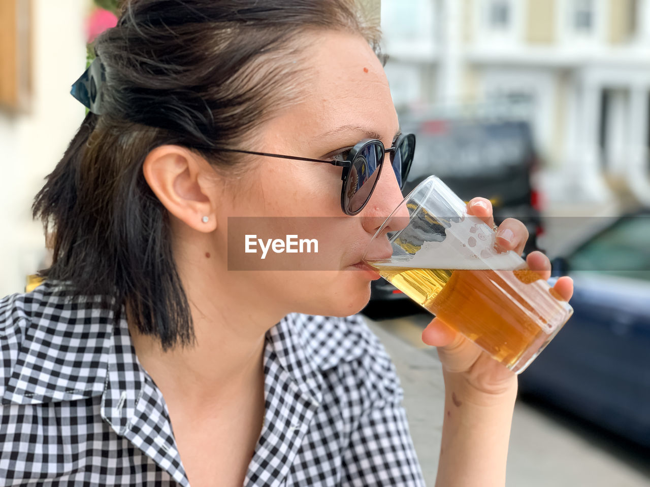 Young woman is drinking beer in a cafe or restaurant pub outdoor. drinking alcohol. candid