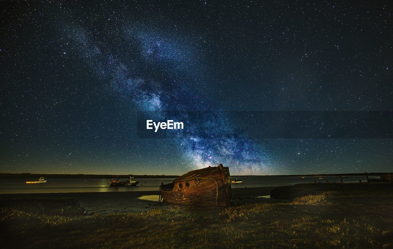 Scenic view of star field against sky at night over shipwreck