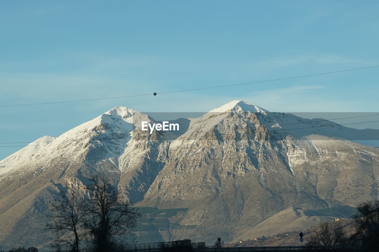 Low angle view of snow covered mountains against sky