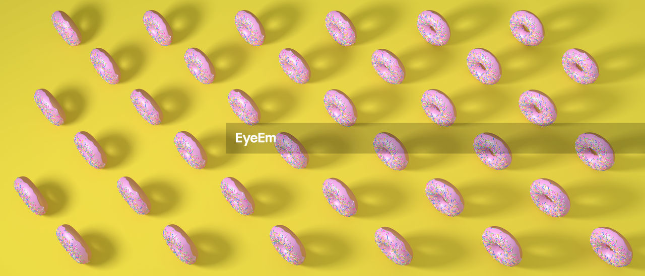 High angle view of donuts on yellow background