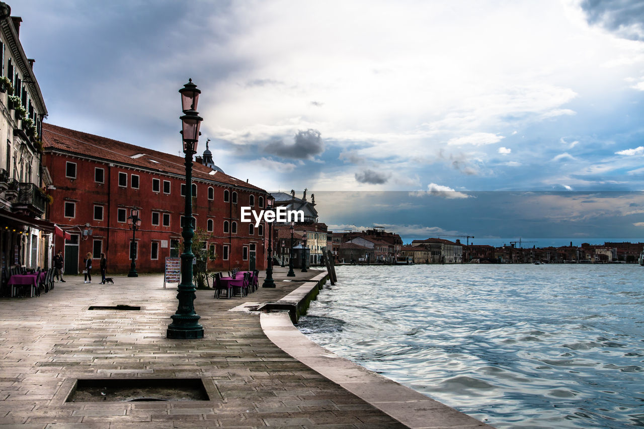 Promenade by grand canal against sky