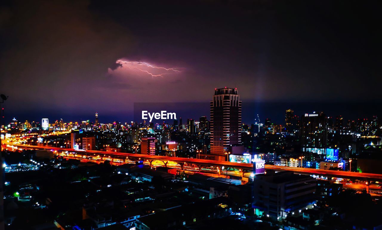 Illuminated city against sky at night