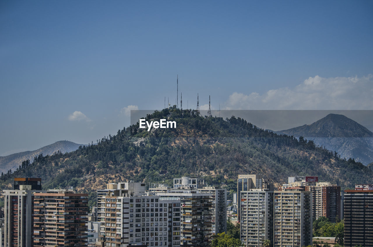 Buildings in city against cloudy sky