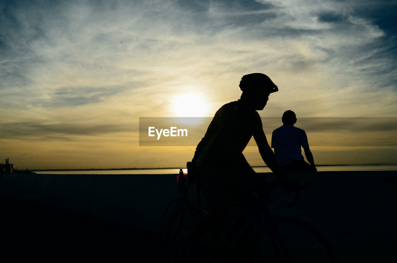 SILHOUETTE COUPLE AGAINST SKY DURING SUNSET