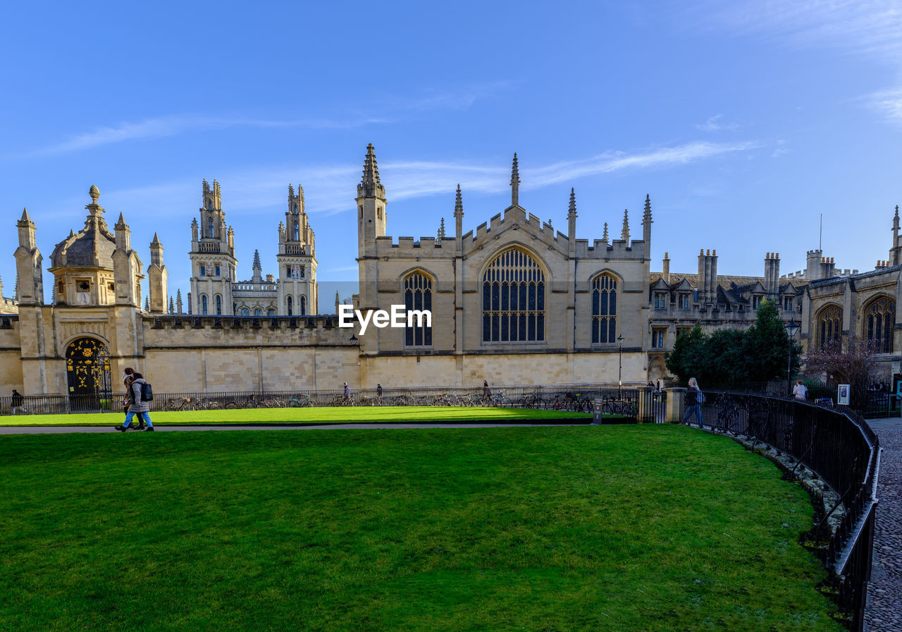 architecture, built structure, building exterior, travel destinations, sky, château, travel, landmark, building, nature, grass, history, the past, city, tourism, estate, religion, stately home, place of worship, palace, blue, cloud, castle, plant, belief, outdoors, tower, government, spirituality, worship, mansion, day, catholicism, cityscape, lawn, landscape