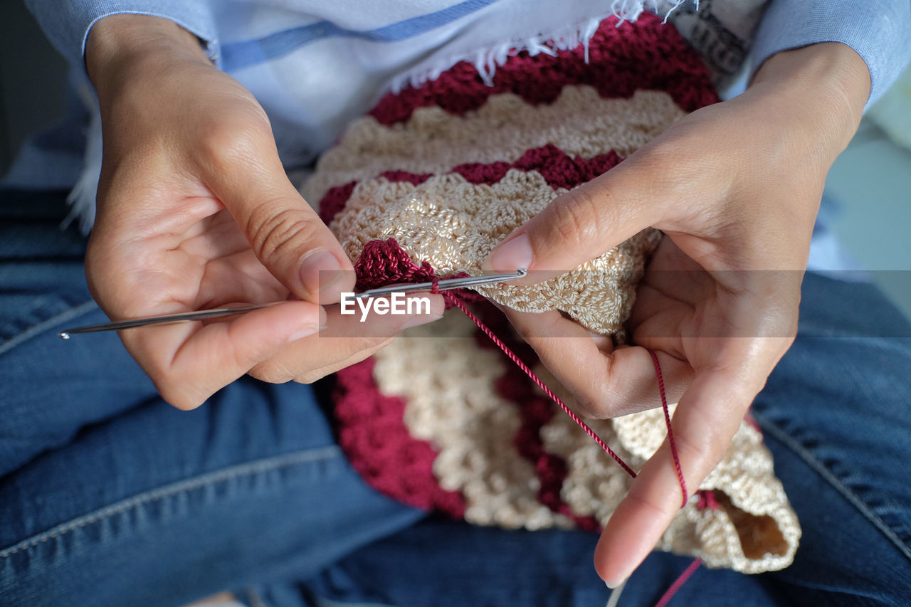 Craftsman is actively knitting using nylon yarn and knitting tools