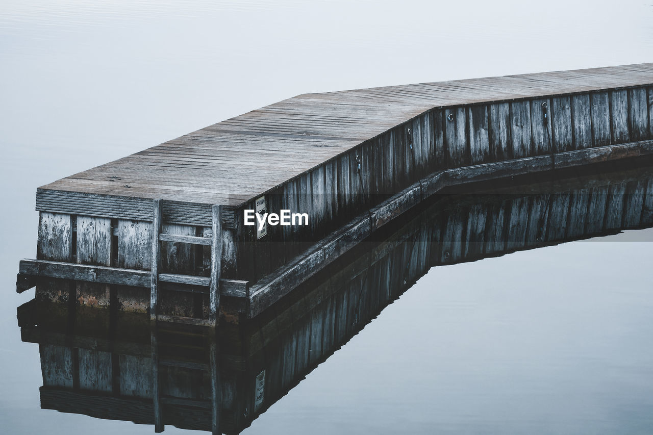 LOW ANGLE VIEW OF BRIDGE OVER LAKE AGAINST SKY