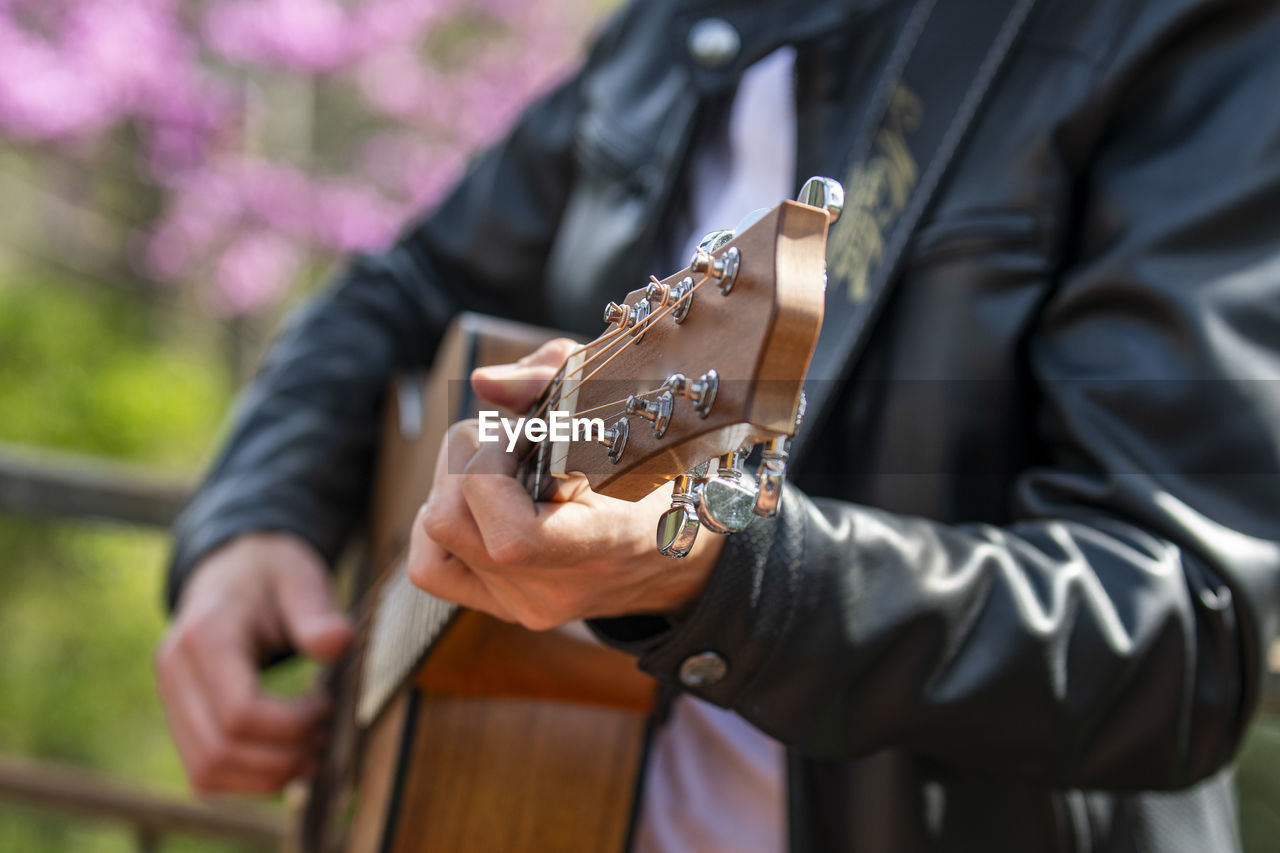 Midsection of man playing guitar