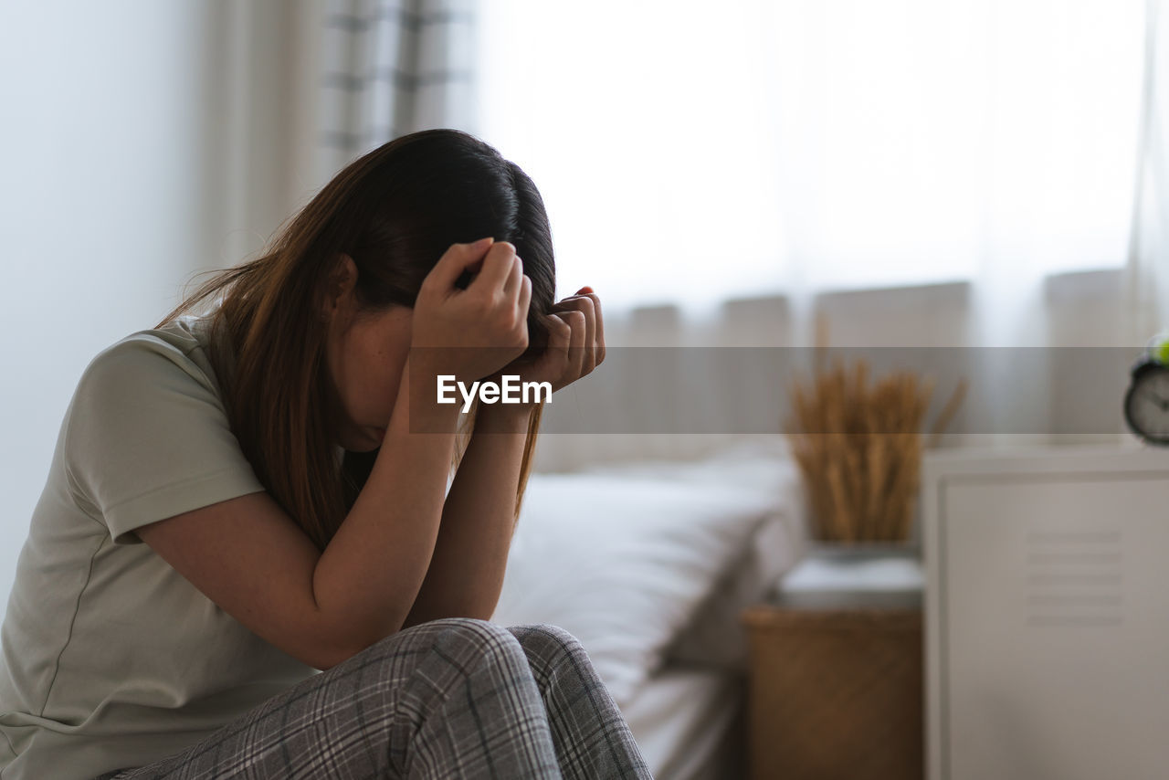 young woman using mobile phone while sitting at home