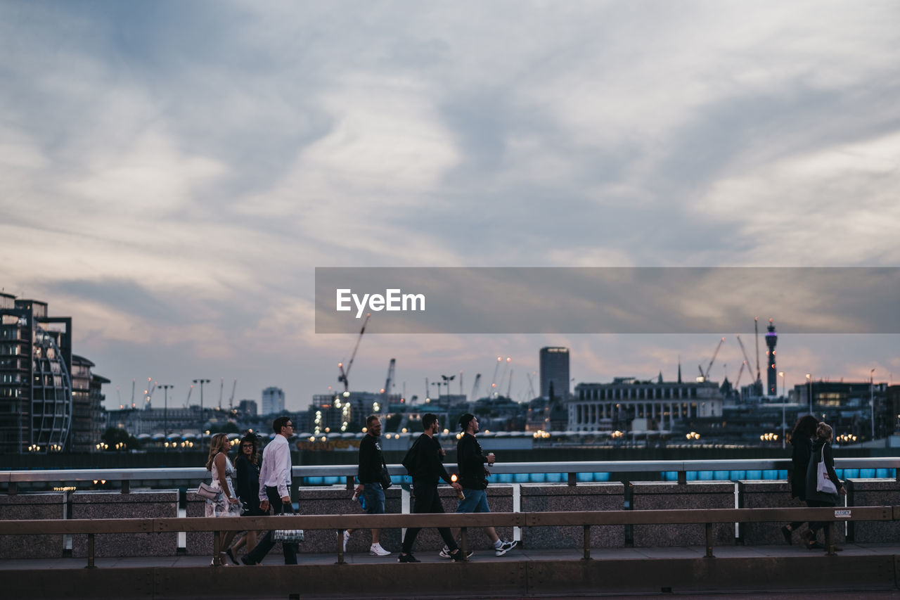 PEOPLE ON BRIDGE OVER RIVER IN CITY