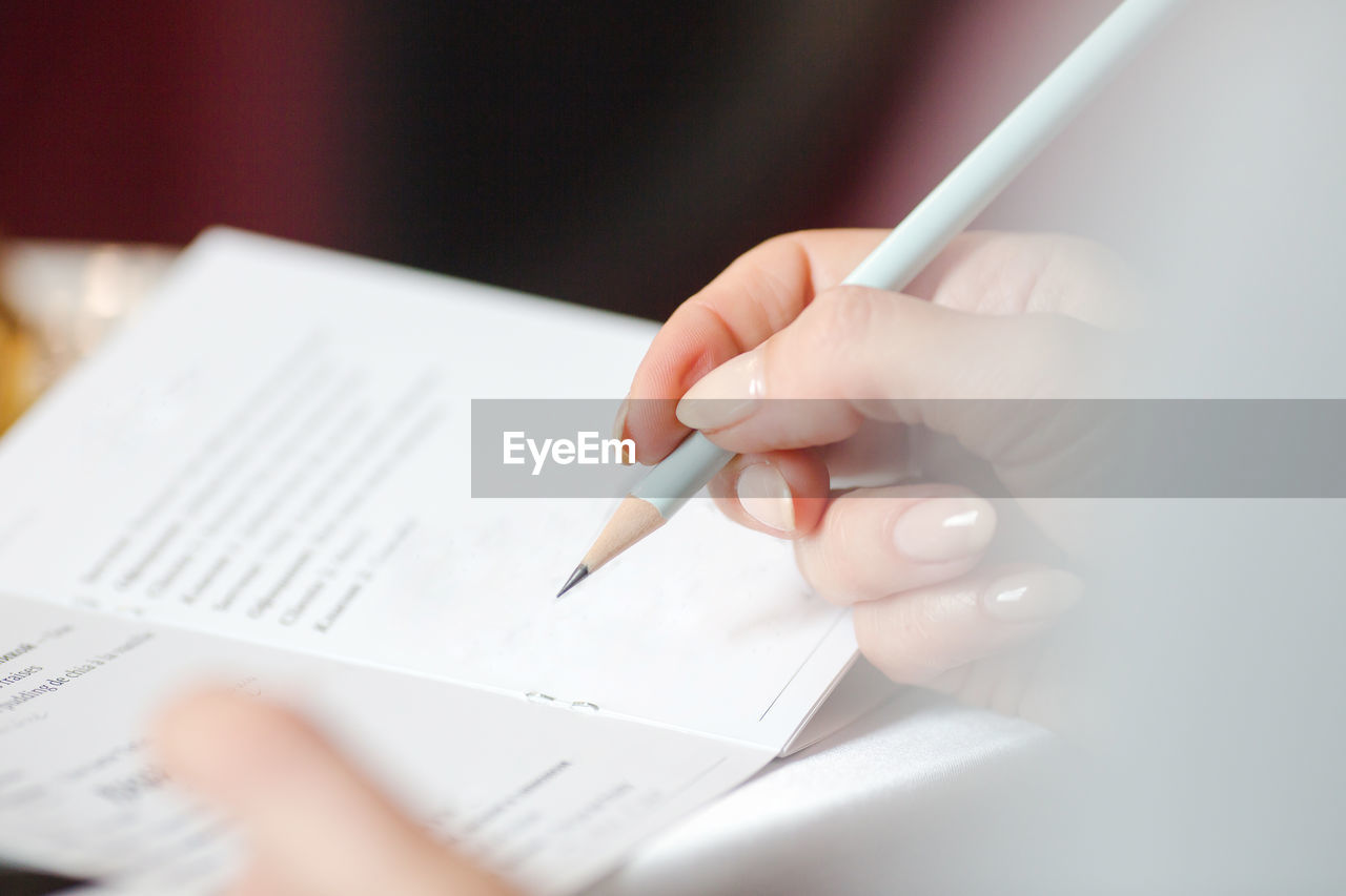 Woman's hand writing in a booklet entry