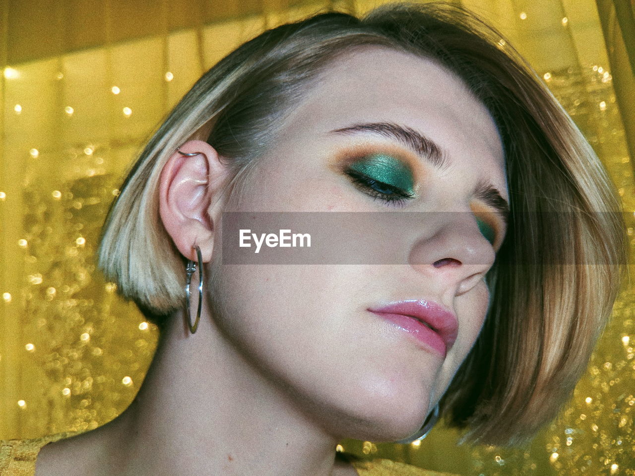 Close-up of young woman with short hair and make-up