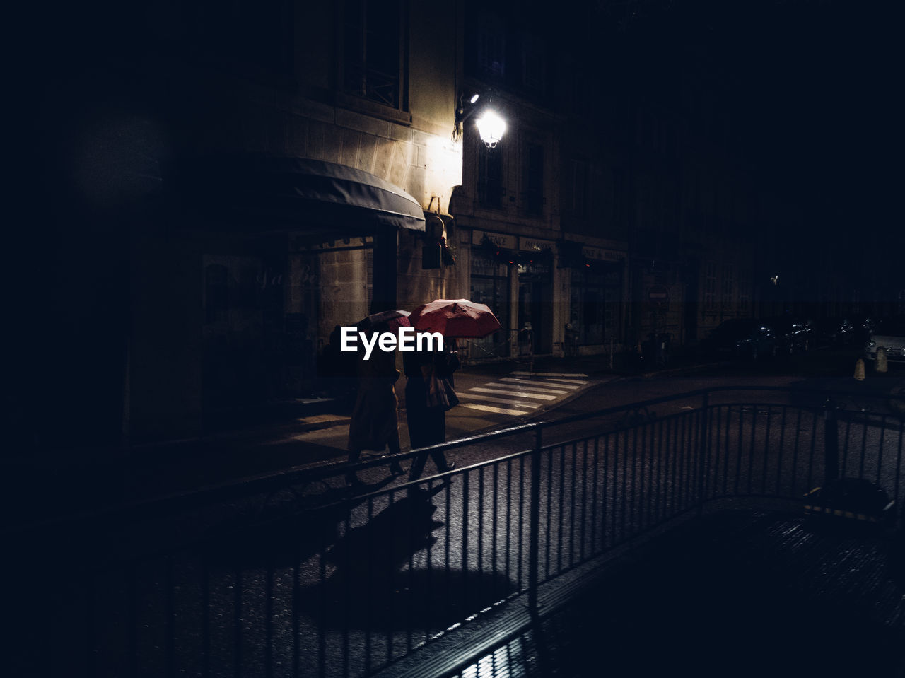 People walking on wet street at night