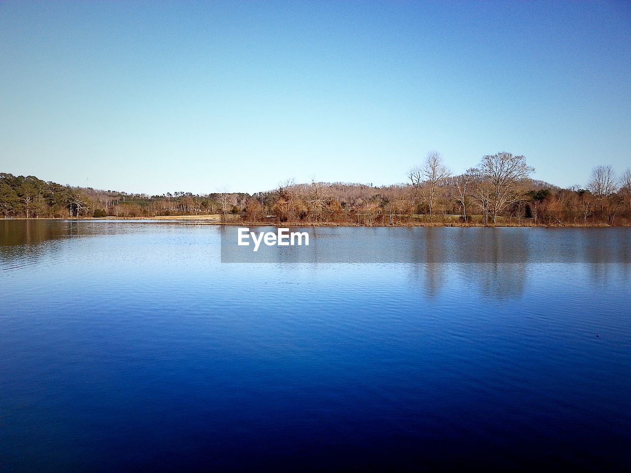 Scenic view of calm lake against blue sky