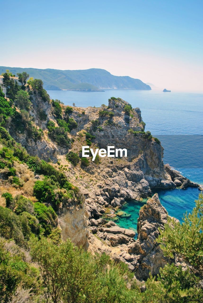 Scenic view of sea and mountains against clear sky