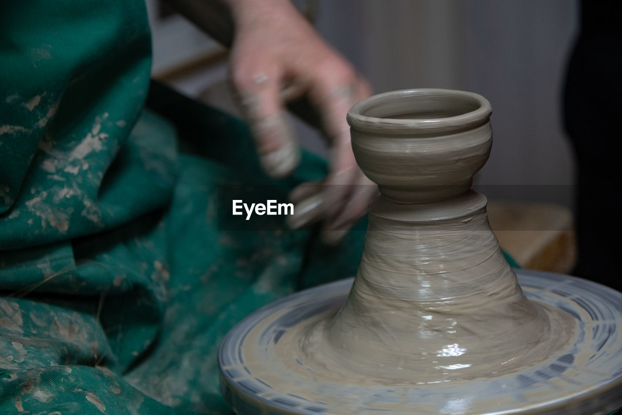 potter's wheel, art, pottery, craft, skill, occupation, spinning, clay, ceramic, expertise, molding a shape, working, creativity, craftsperson, hand, making, wheel, workshop, earthenware, motion, one person, mud, adult, craft product, pitcher - jug, indoors, shape, art and craft product