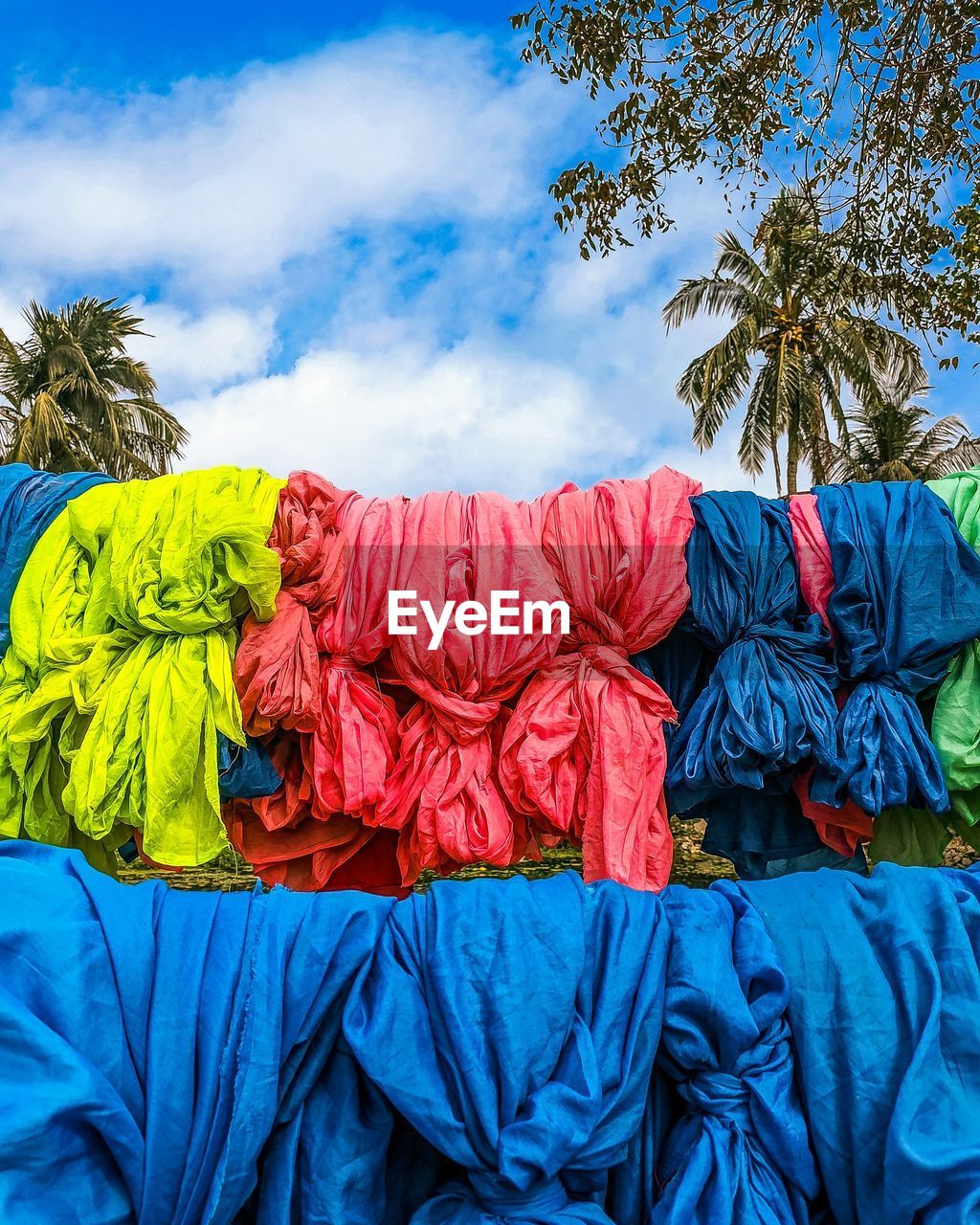 LOW ANGLE VIEW OF UMBRELLAS AGAINST BLUE SKY