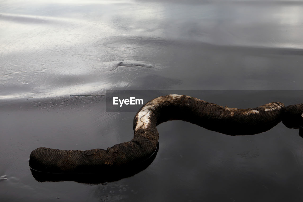 HIGH ANGLE VIEW OF RUSTY CHAIN ON WOODEN LAKE