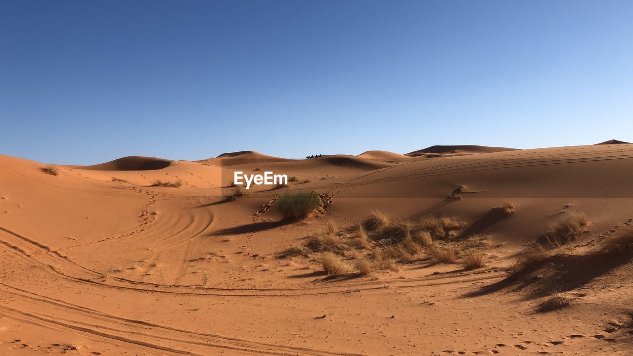 Scenic view of desert against clear blue sky