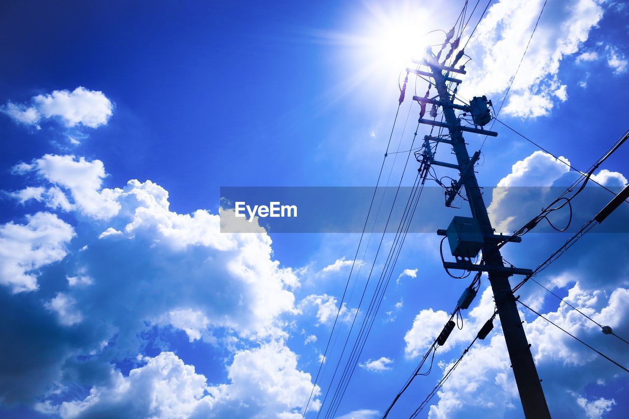 Low angle view of electricity pole against blue sky