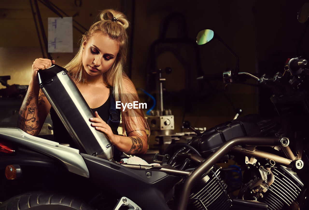 Female mechanic working in motorcycle workshop