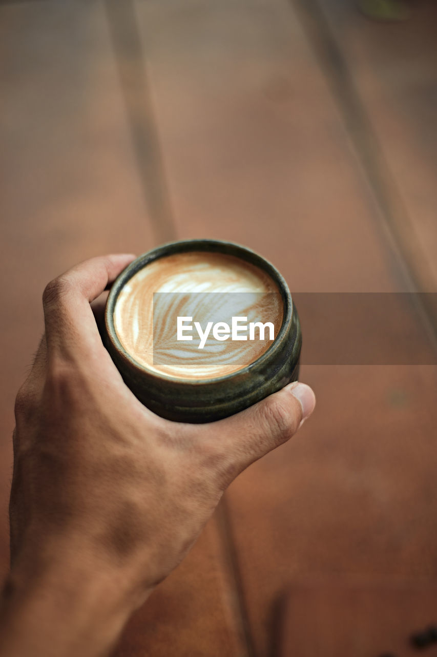 HIGH ANGLE VIEW OF COFFEE HOLDING CUP OF CAPPUCCINO