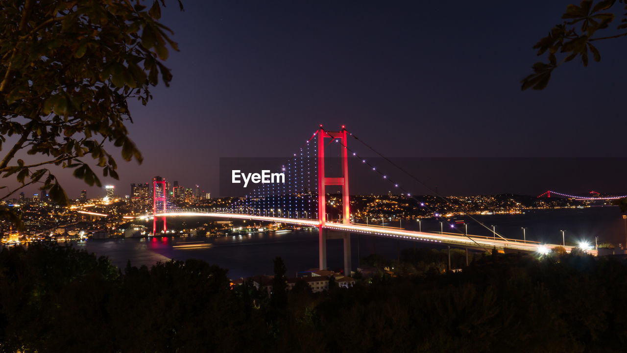 Istanbul bosphorus bridge at night, illuminated bridge over river with city in background