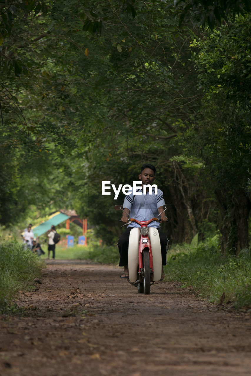 Full length of a man riding scooter