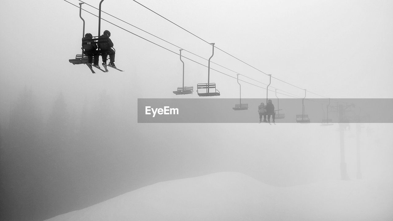 Low-angle view of young couple on ski lift