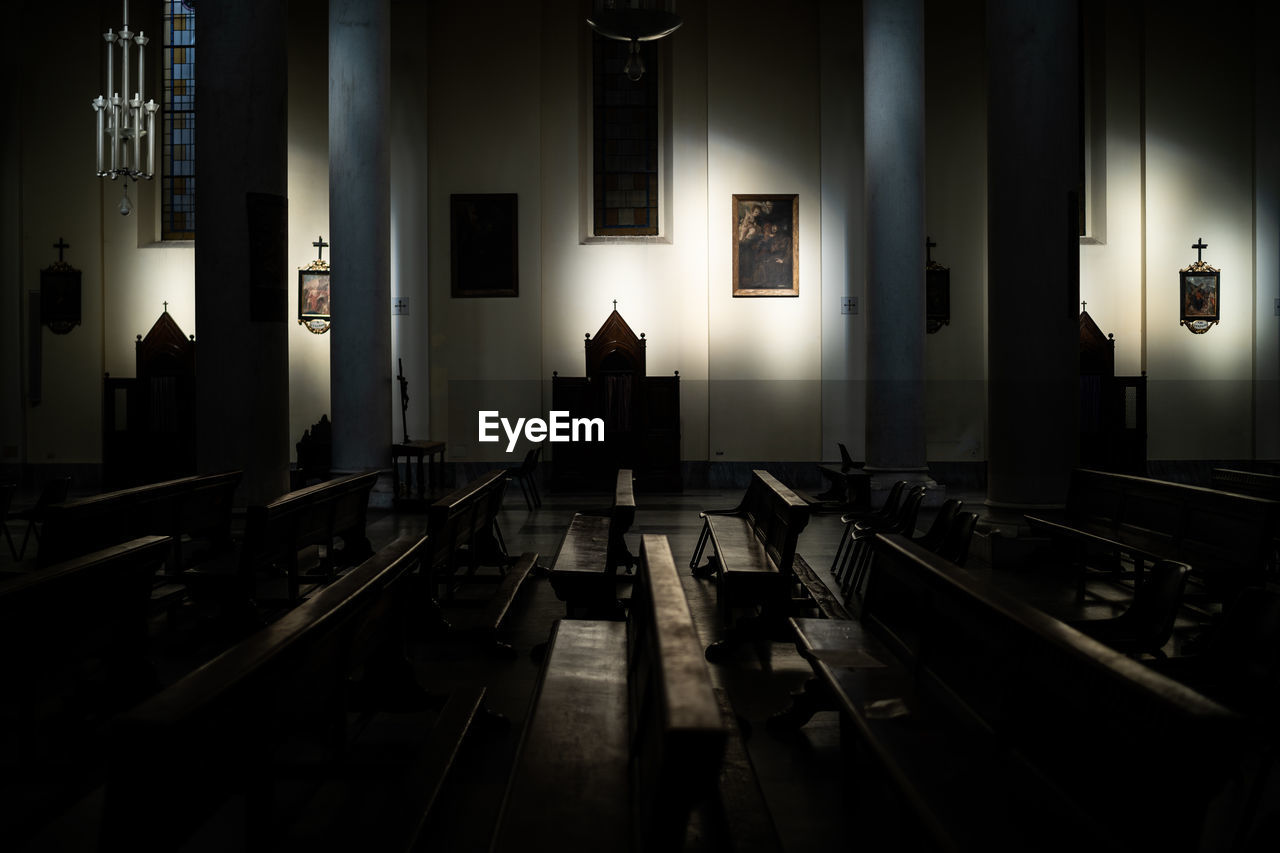 Empty chairs and tables in illuminated building