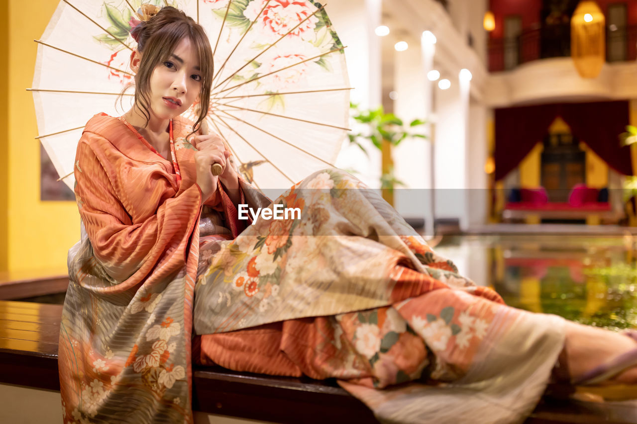 Portrait of beautiful woman wearing traditional clothing sitting indoors