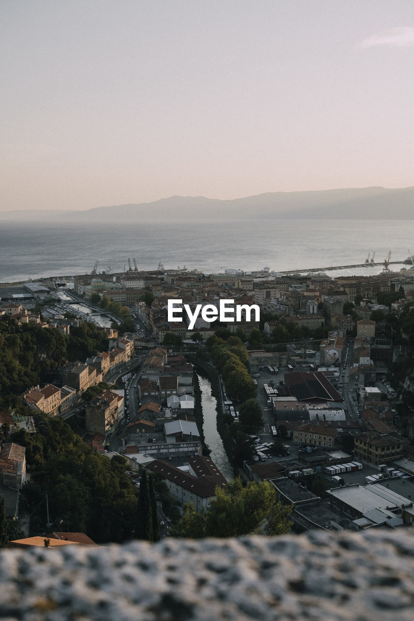 Aerial view of buildings in city against clear sky