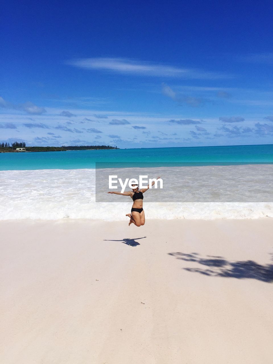 Full length of woman jumping at beach