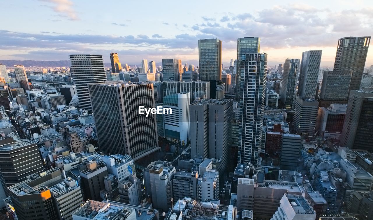 Bird aerial view of modern city high rise building agaist the sky