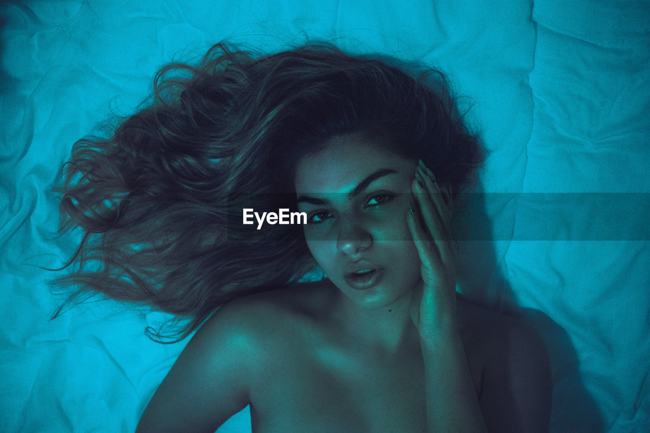 Portrait of woman lying on bed