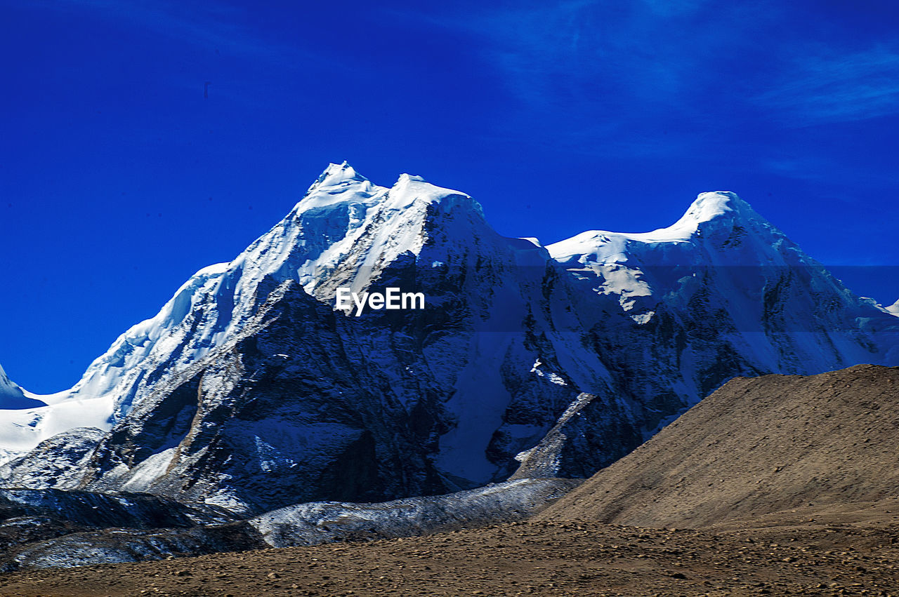 SNOWCAPPED MOUNTAINS AGAINST BLUE SKY