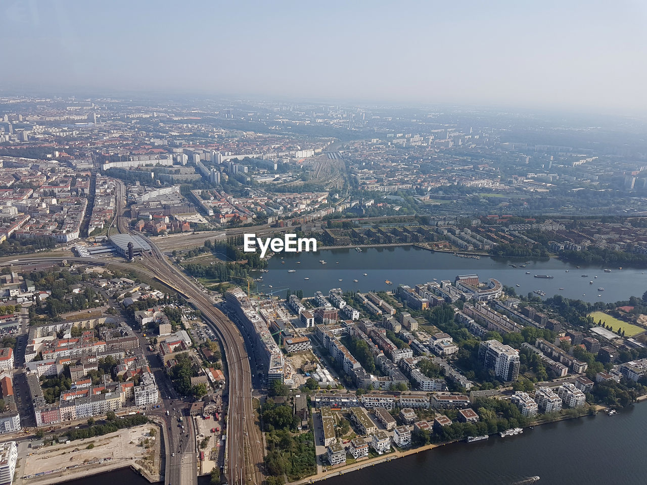 HIGH ANGLE VIEW OF RIVER AMIDST BUILDINGS AGAINST SKY