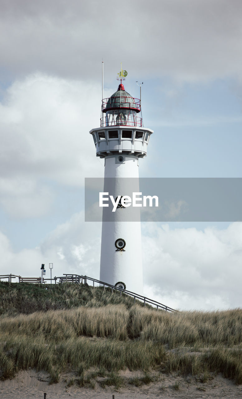 Lighthouse by sea against sky