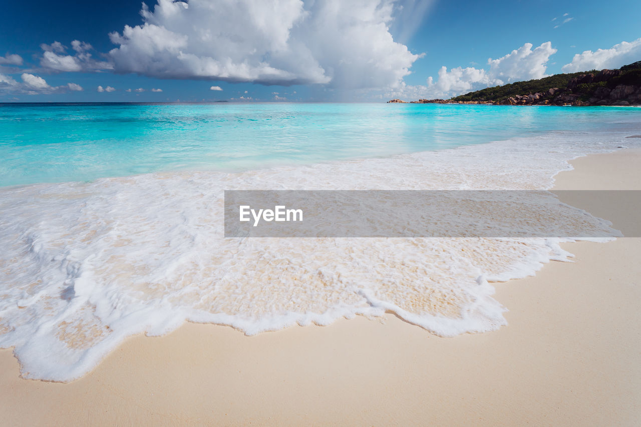 Scenic view of beach against cloudy sky