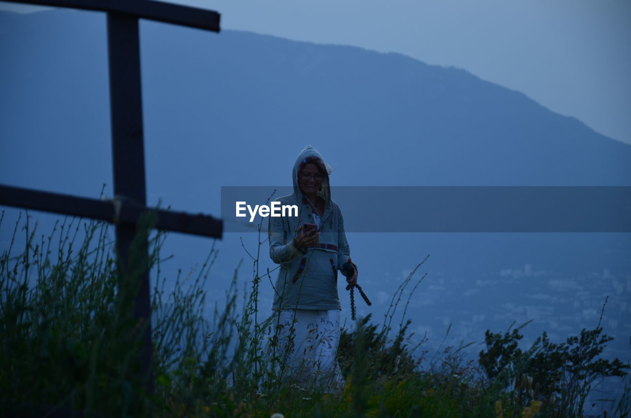 Woman standing on field against sky