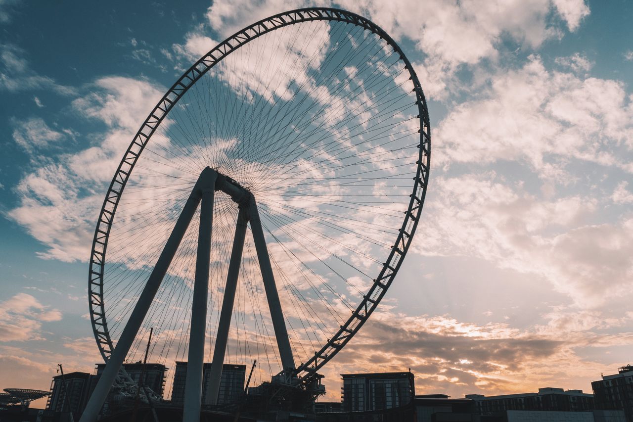 LOW ANGLE VIEW OF FERRIS WHEEL IN CITY AGAINST SKY