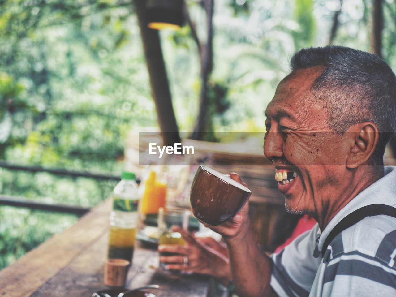 Portrait of the happy old man having a cup of coffee