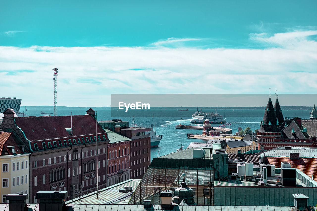 High angle view of townscape by sea against sky
