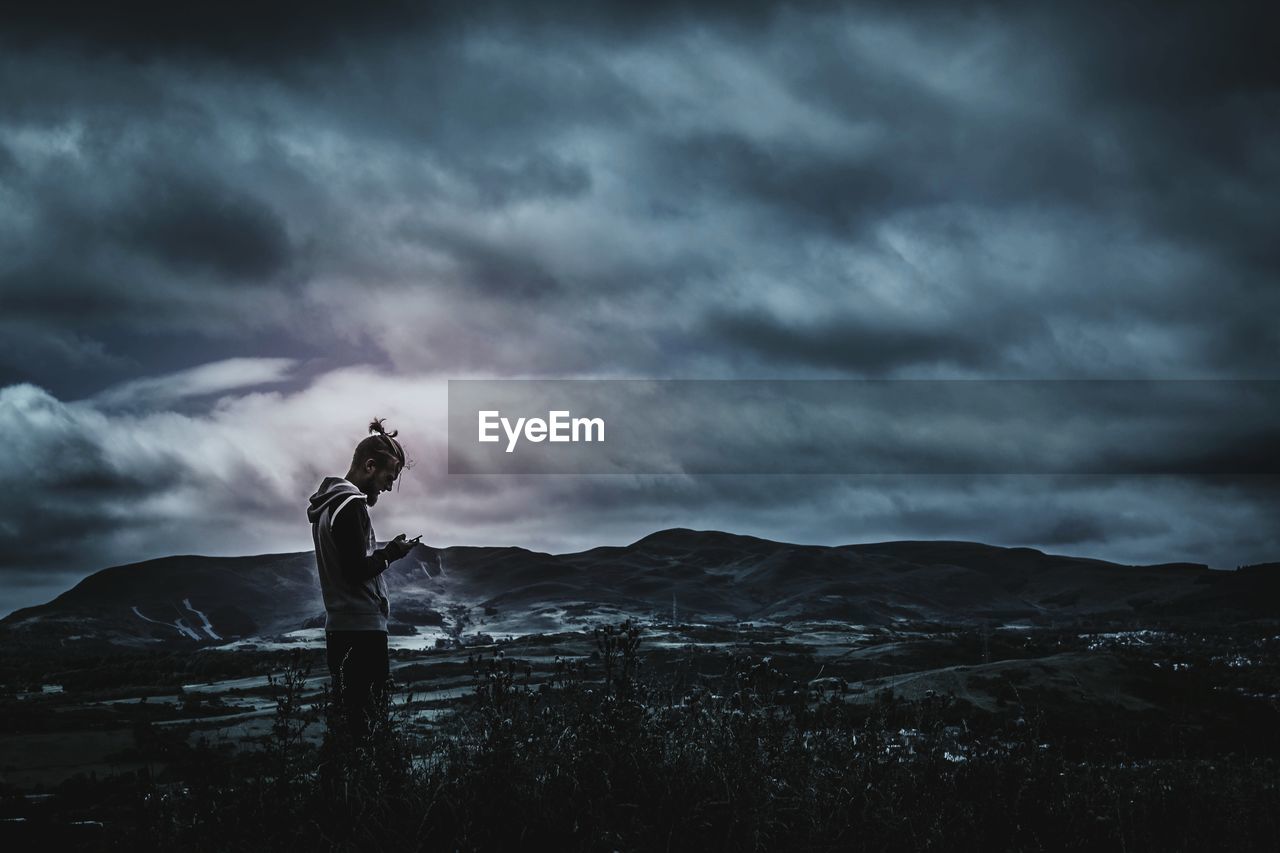 SILHOUETTE OF TREES ON LANDSCAPE AGAINST CLOUDY SKY